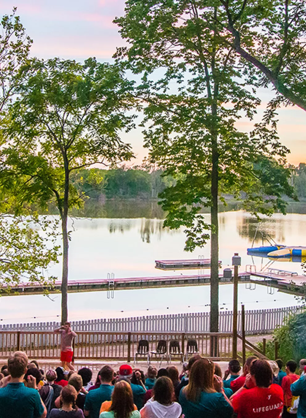 campers at waterfront amphitheater at sunset
