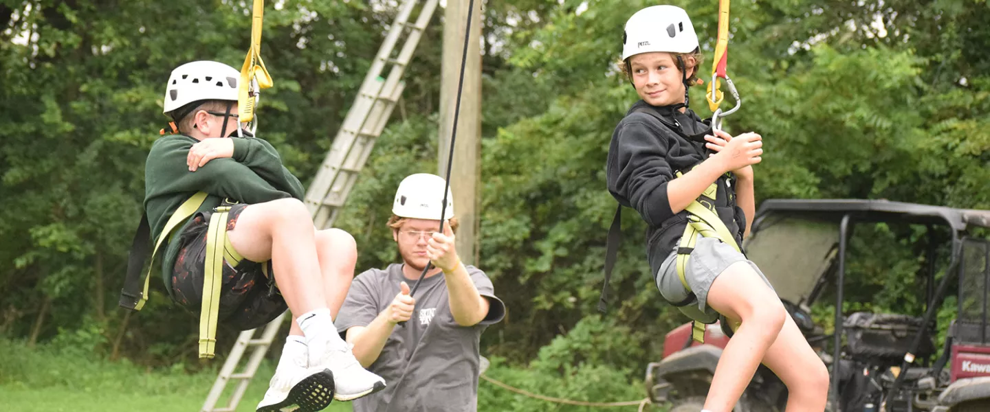 Campers on giant swing with staff looking on