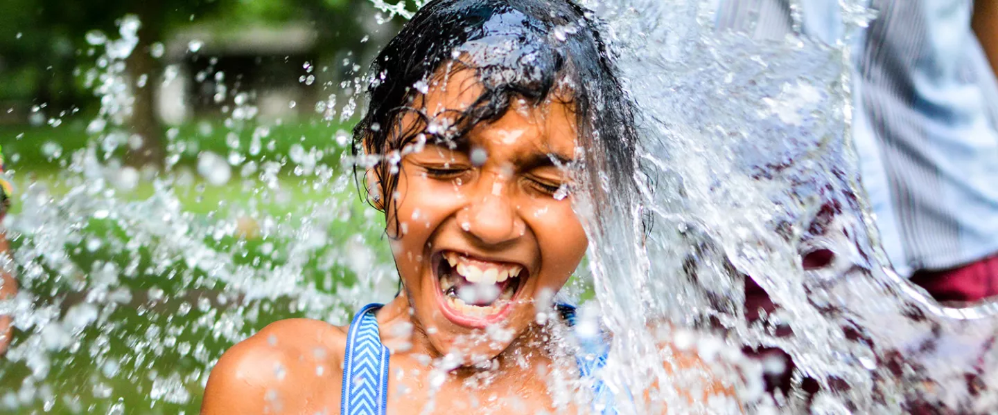 Camper getting water dumped on them while smiling