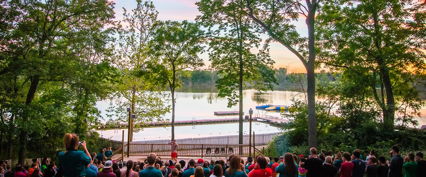 campers at waterfront amphitheater at sunset