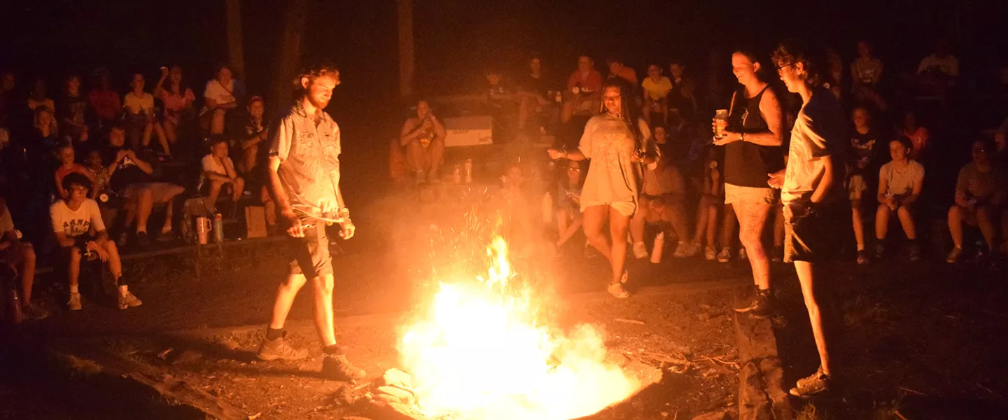 people around a roaring campfire