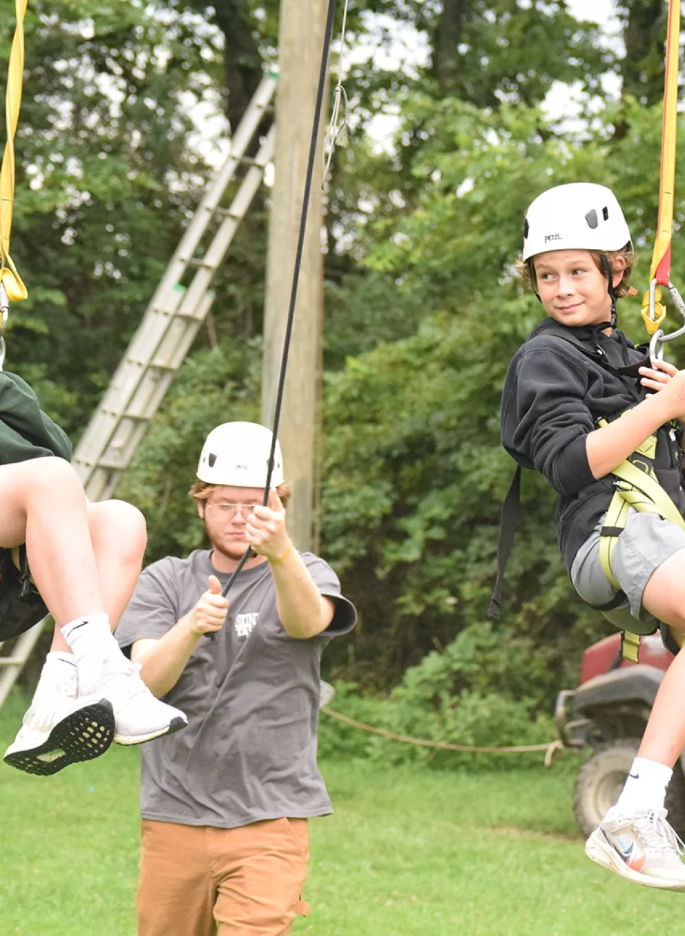 Campers on giant swing with staff looking on