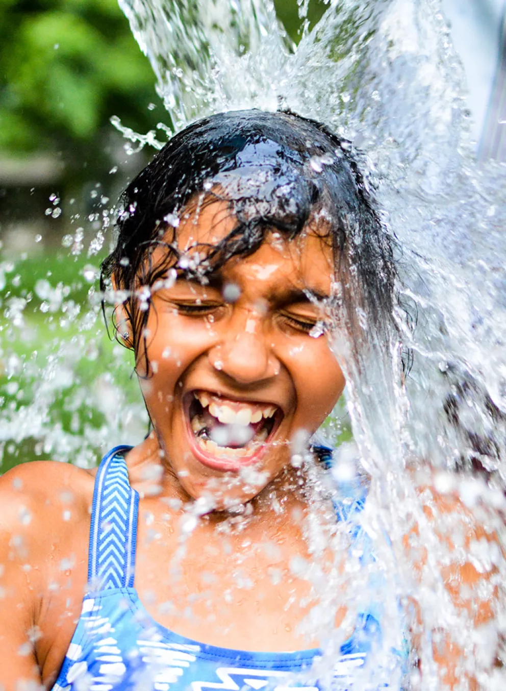 Camper getting water dumped on them while smiling