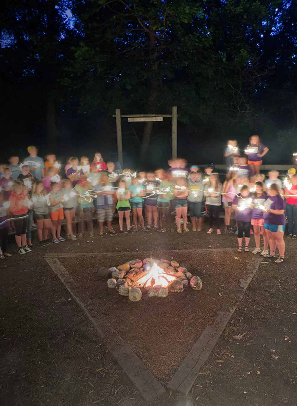campers and staff around a campfire