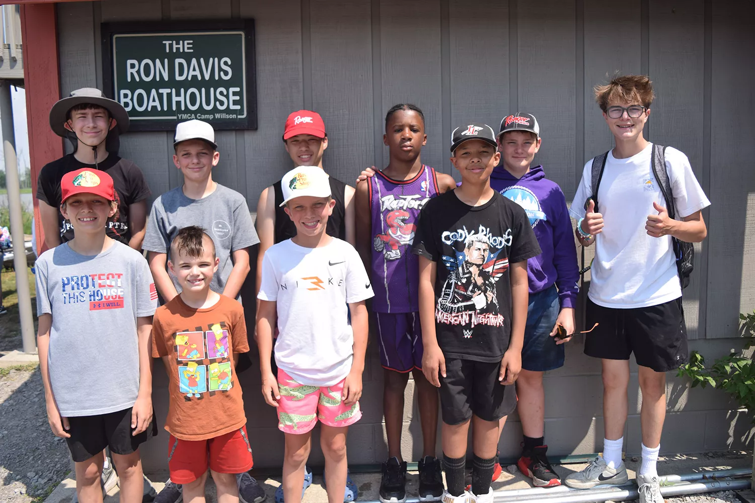 Group of fishing campers posing by the boathouse