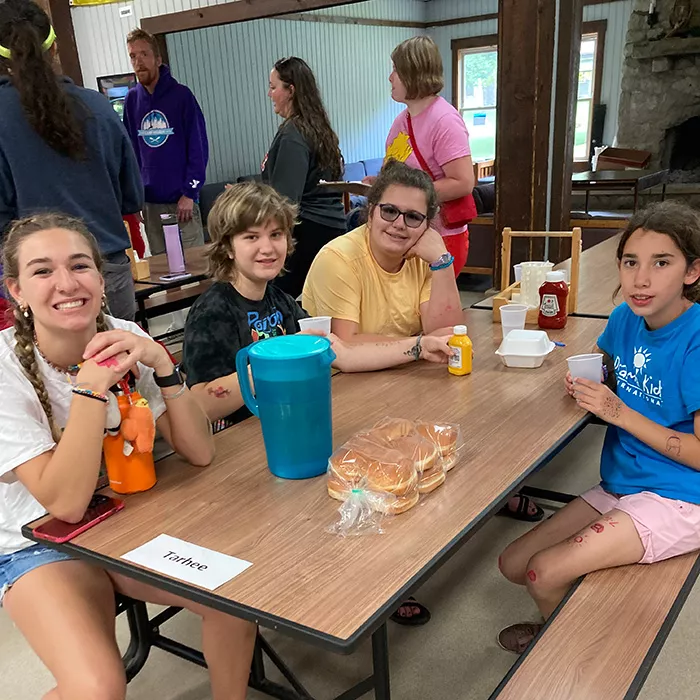 Campers smiling while sitting at a dining table