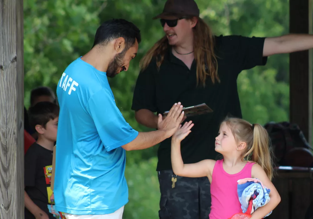 Staff and camper high fiving