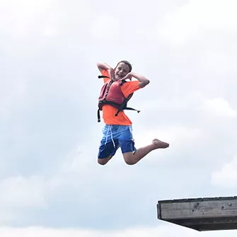 Camper jumping into the water