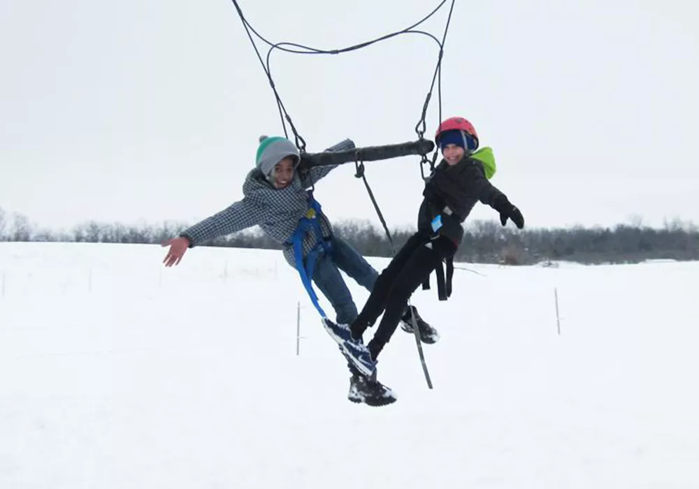 campers on the giant swing with snow on the ground