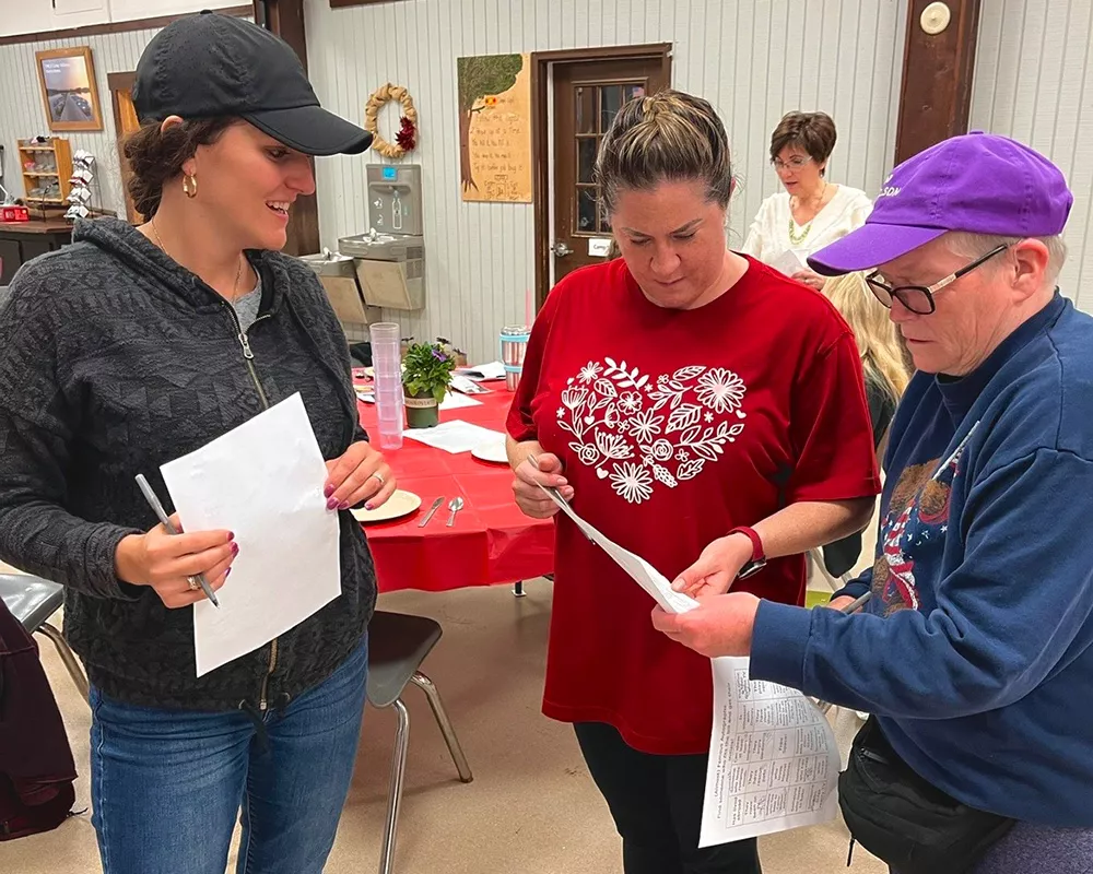 Women's Weekend campers checking papers