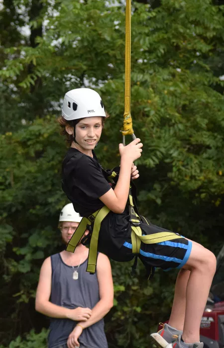 child on adventure ride with staff looking on