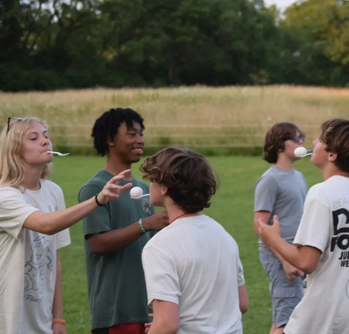 campers playing a game transferring eggs with spoons in their mouths